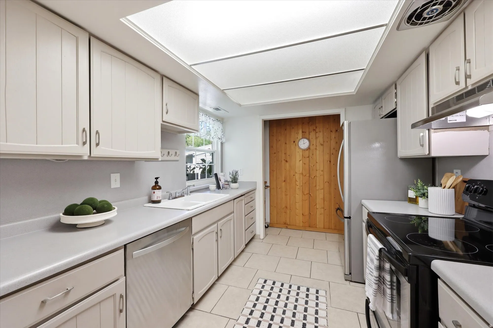 Well-appointed kitchen featuring light-toned cabinetry and light countertops