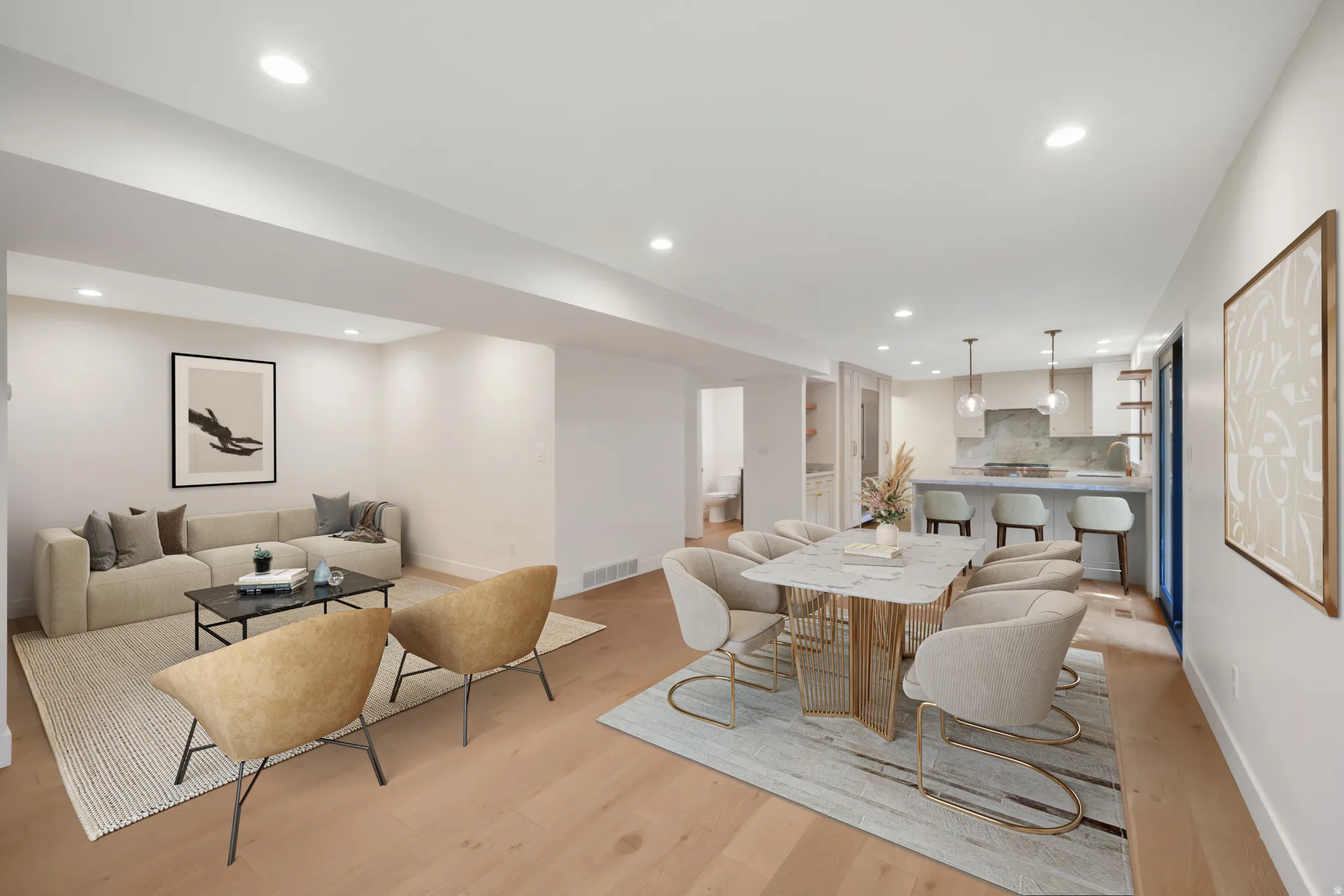 Open-concept living space featuring wood-finish flooring, recessed lighting, and a kitchen with an island breakfast bar