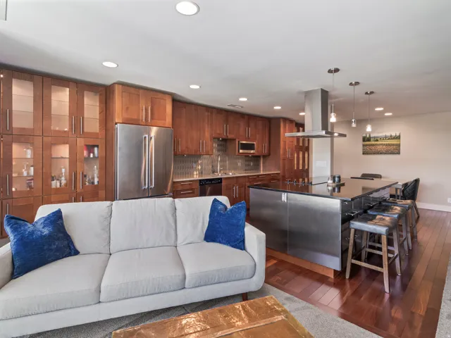 Open-concept living space featuring wood-finish flooring and recessed lighting with massive storage and display cabinetry