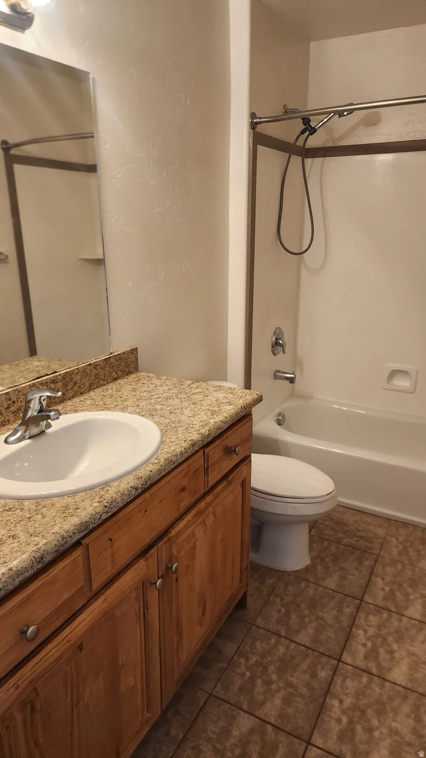 Bathroom featuring a light-toned vanity with an oval sink and granite-style countertop