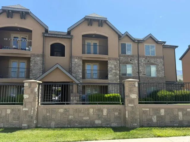 Multi-story building featuring a stucco exterior with stone accents and multiple balconies
