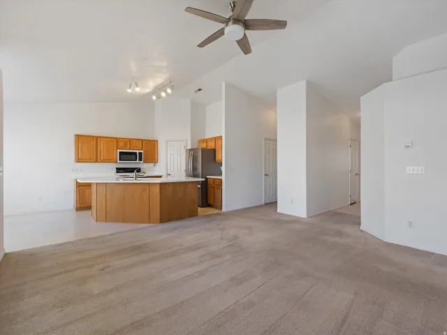 Open concept living area featuring vaulted ceilings, a ceiling fan, and track lighting
