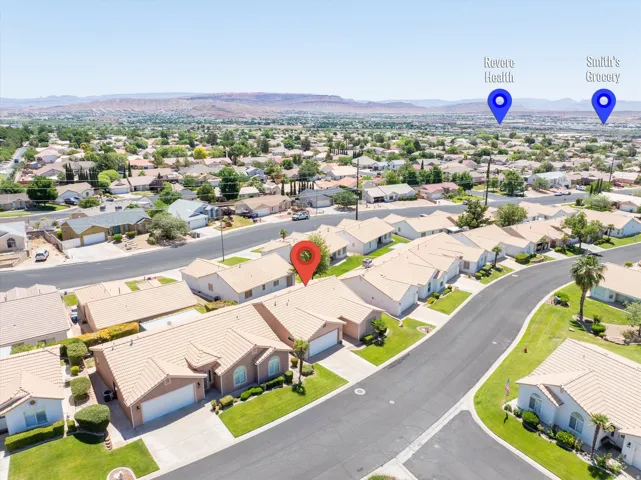 Residential neighborhood featuring single-story homes with light-colored roofs and landscaped front yards