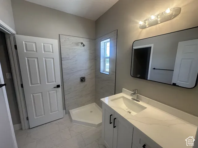 Contemporary bathroom featuring a white vanity with an integrated sink, a tiled shower with a built-in window, and a large wall mirror