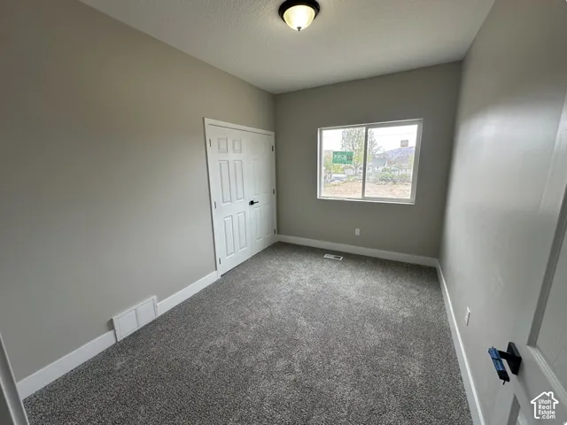 Neutral tone walls with white baseboards and gray carpet