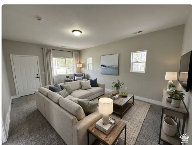 Spacious living area featuring neutral-toned walls, plush carpeting, a multi-pane window, ceiling-mounted light fixture, and a four-panel entry door,  Virtually Staged to give you an idea of space planning