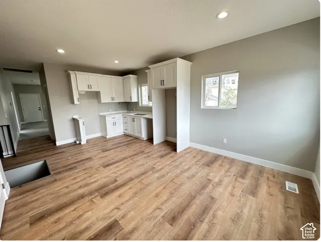 Open concept living space featuring wood-finish flooring, recessed lighting, and a neutral wall palette
