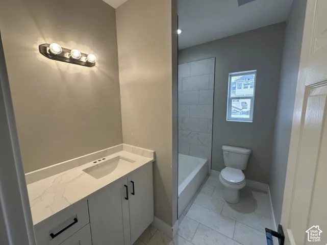 Bathroom featuring a white vanity with a light-toned countertop, a rectangular undermount sink, and black hardware