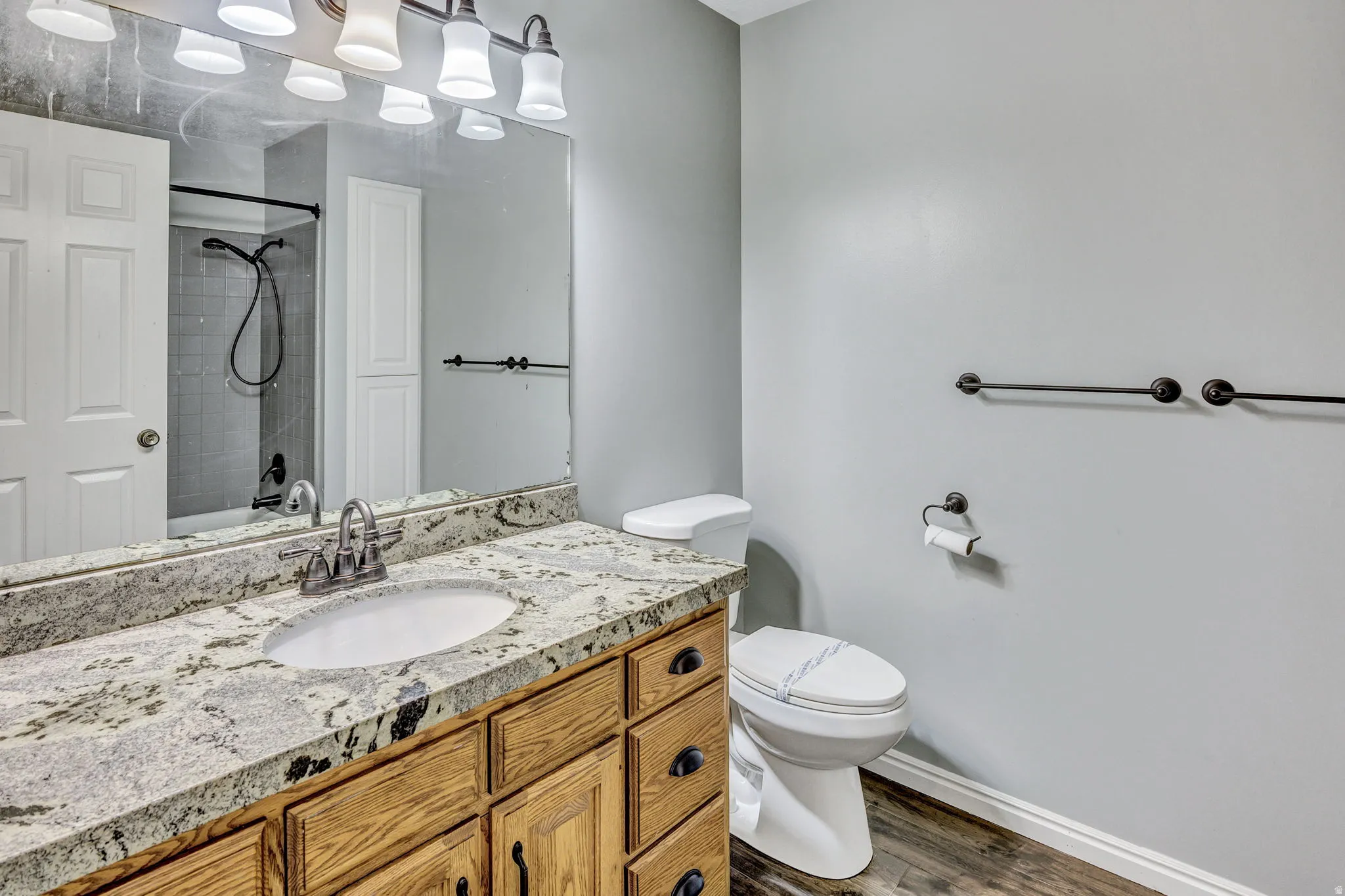 Bathroom vanity featuring a light-toned stone countertop with an undermount sink