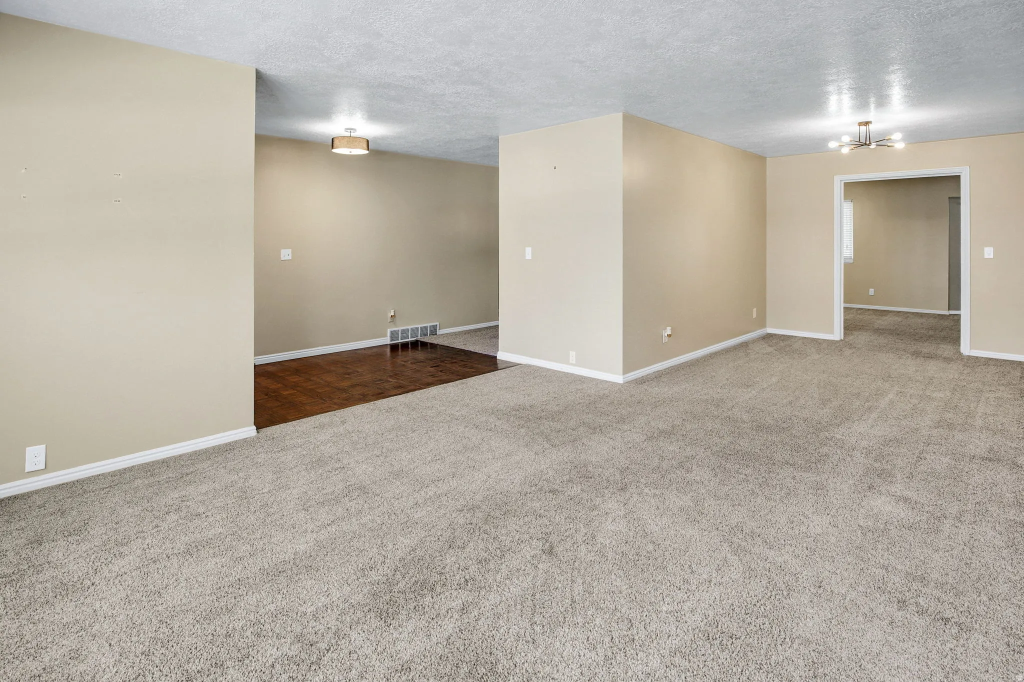 Spacious interior featuring neutral wall tones and light-toned carpeting