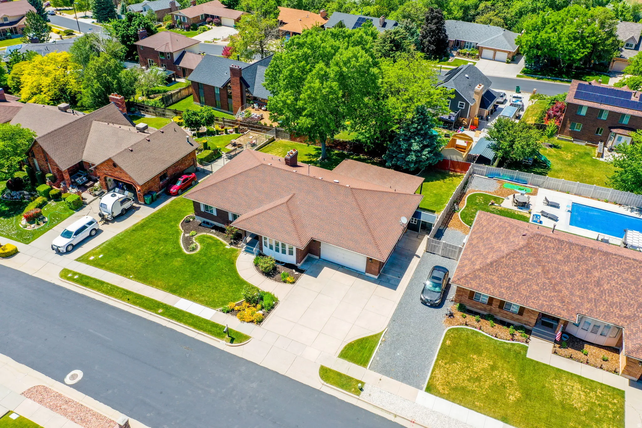 Ranch-style residence featuring a brown shingle roof and brick exterior accents