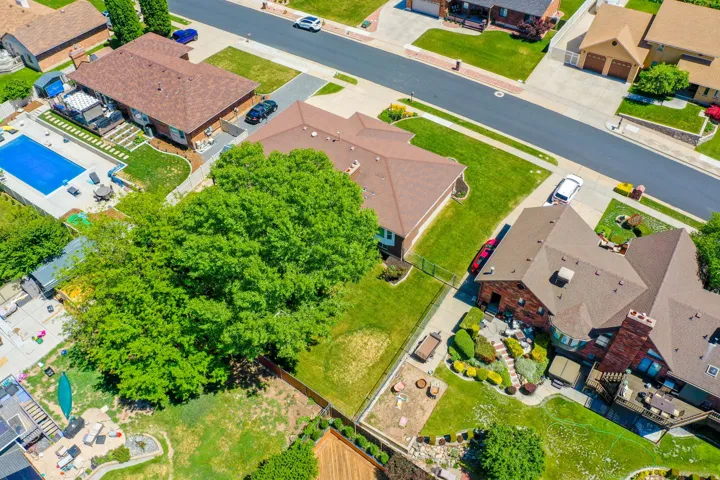 Aerial perspective showcasing a residential property with a brown shingle roof and brick exterior