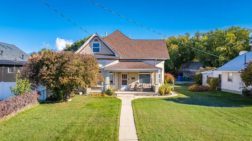 Traditional two-story residence featuring a covered front porch, gabled roofline, and dormer window
