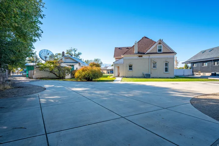 Expansive concrete driveway with additional gravel parking
