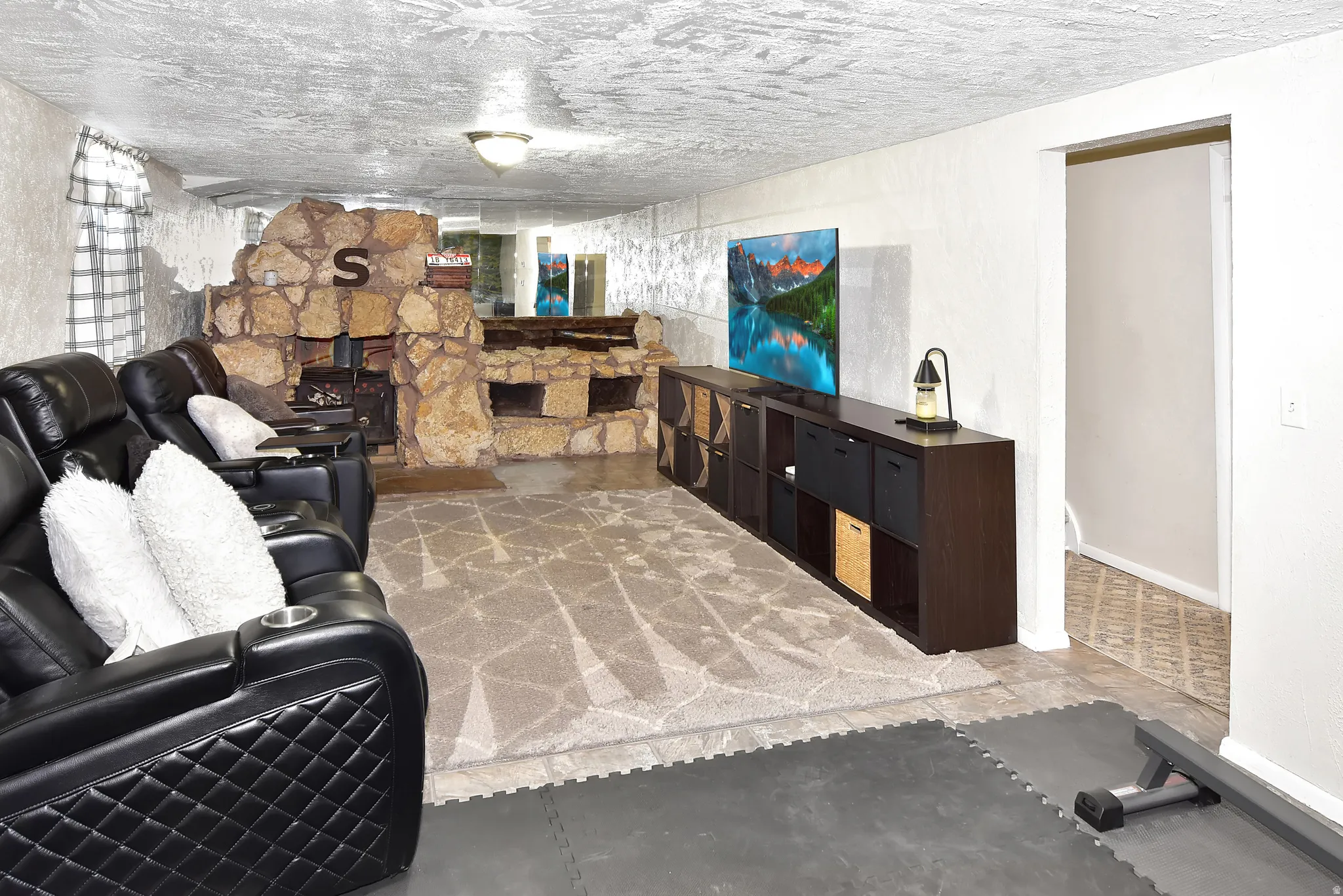 Exposed stone fireplace with a wood-burning insert