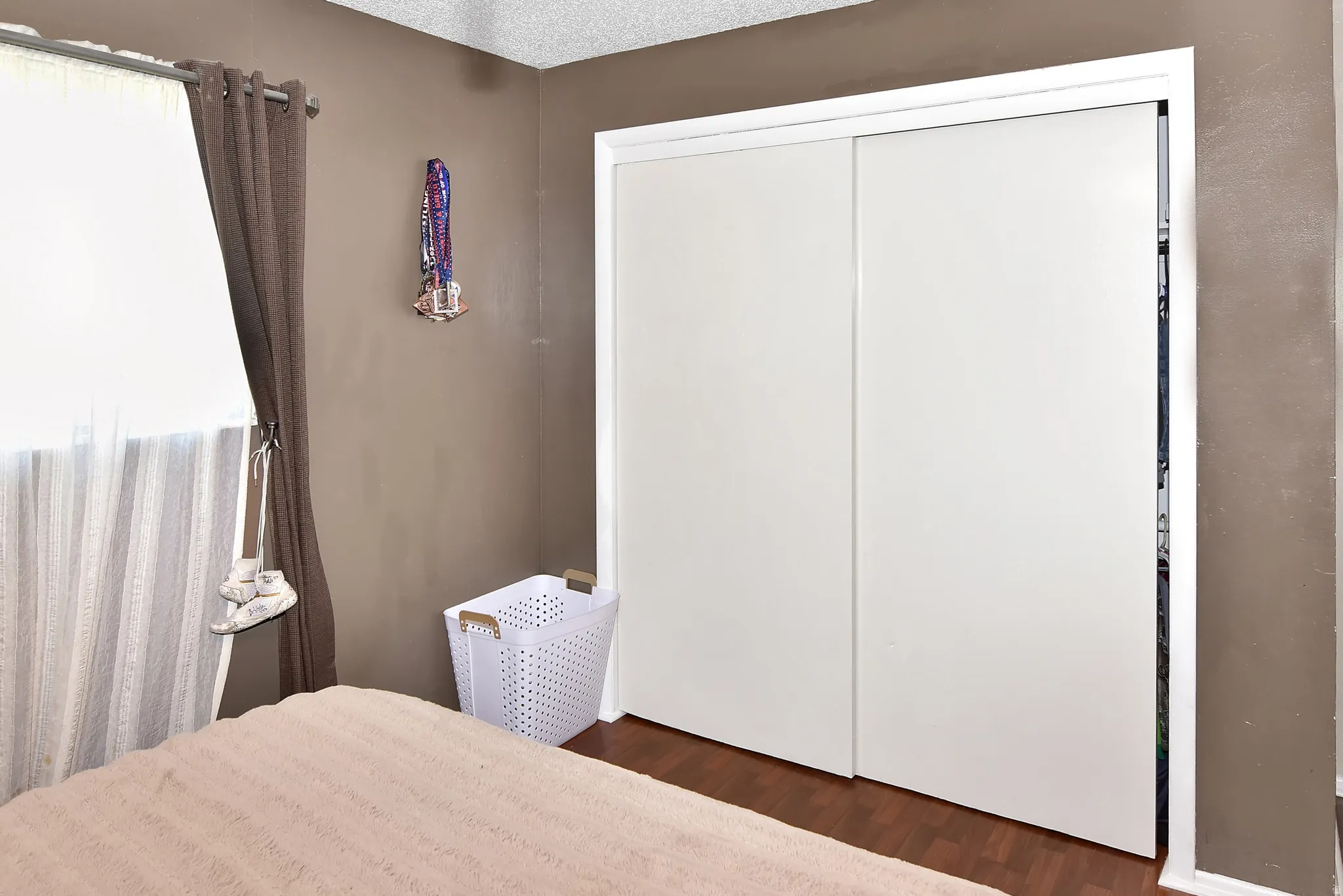 White sliding closet doors with white trim, set against a brown wall