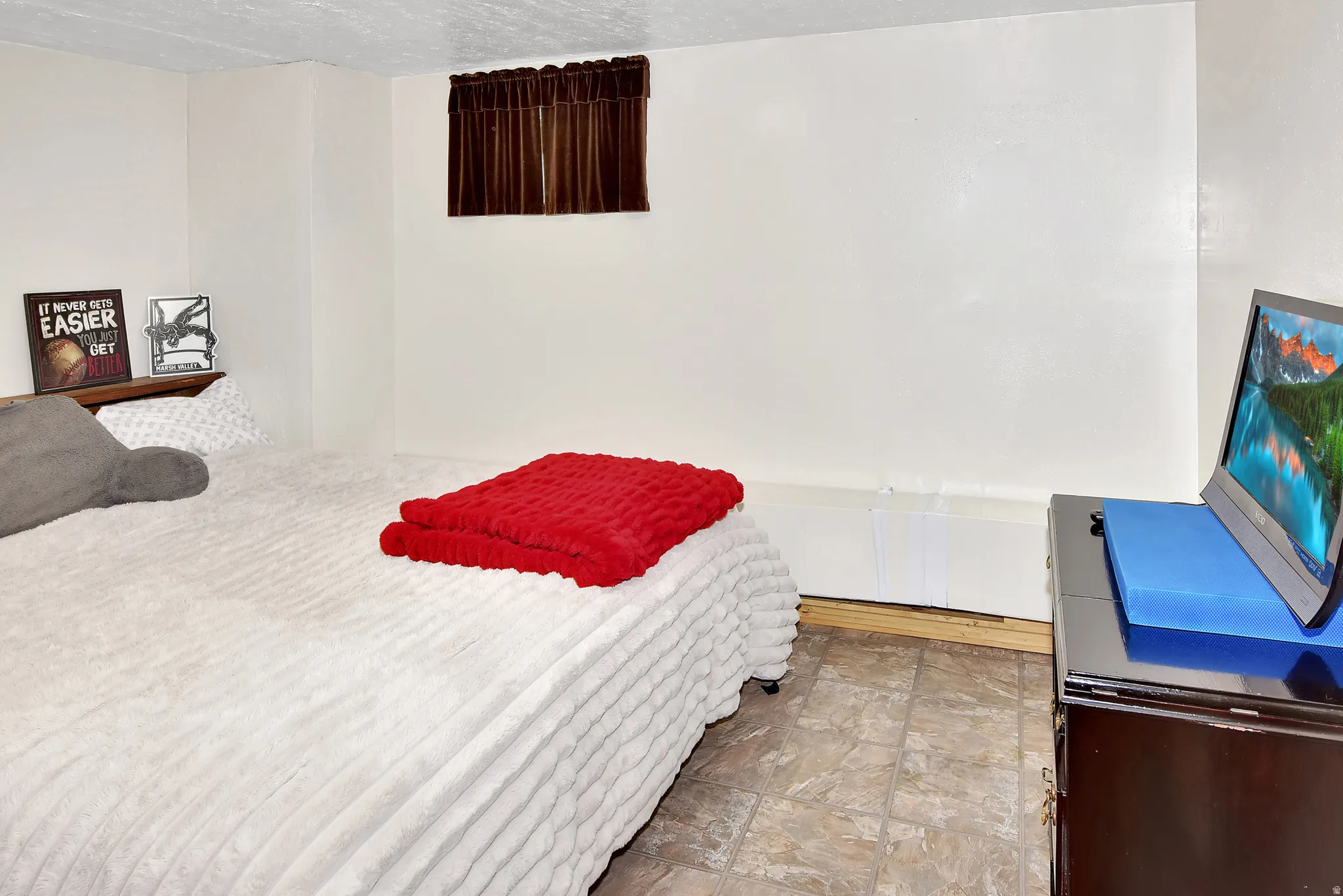 Room featuring neutral wall tones and patterned tile flooring