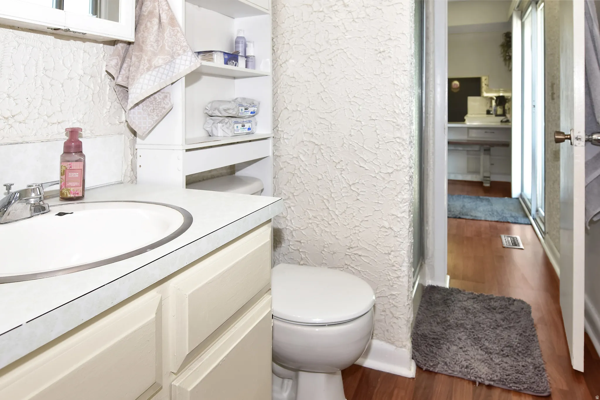 Bathroom featuring a single basin vanity with an integrated sink, a white countertop, and cabinetry below