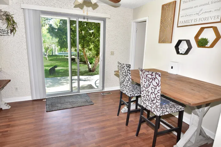 Sliding glass door opening to a private exterior space with mature trees