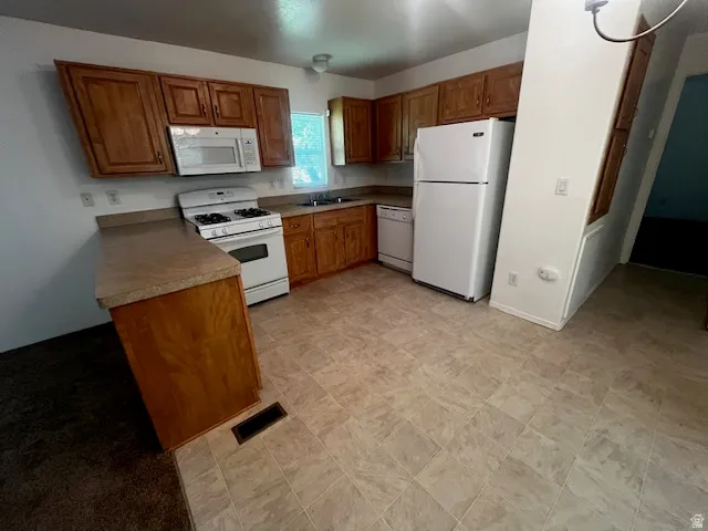 Kitchen featuring wood-finish cabinetry, laminate countertops, and tile-look flooring