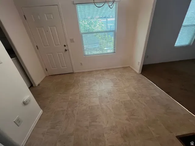 Entryway featuring tile-finish flooring, a paneled door, and a window with blinds