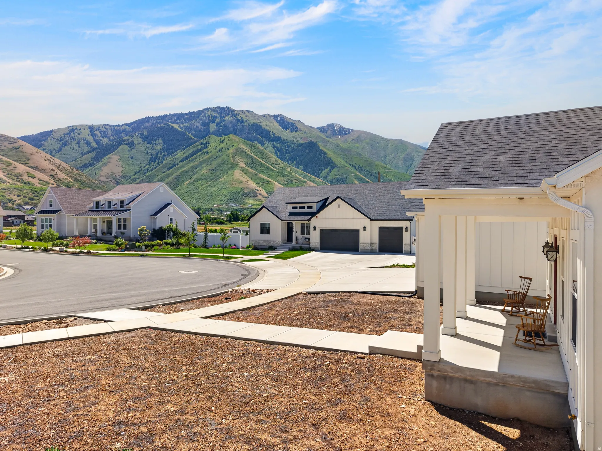 Newly constructed residence featuring a covered front porch with column supports and a dark shingle roof