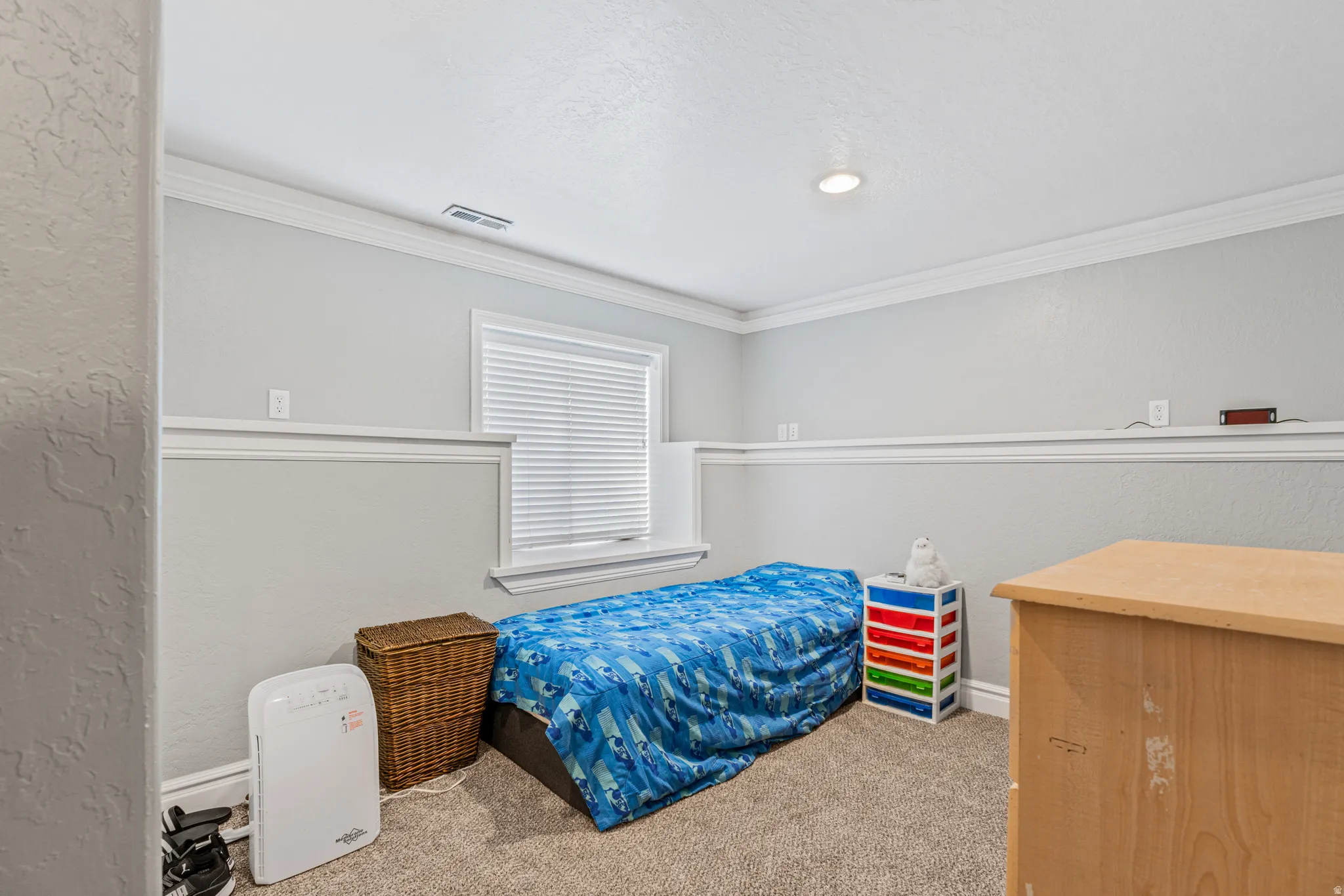 Recessed lighting, crown molding, chair rail molding, textured walls, and a window with blinds