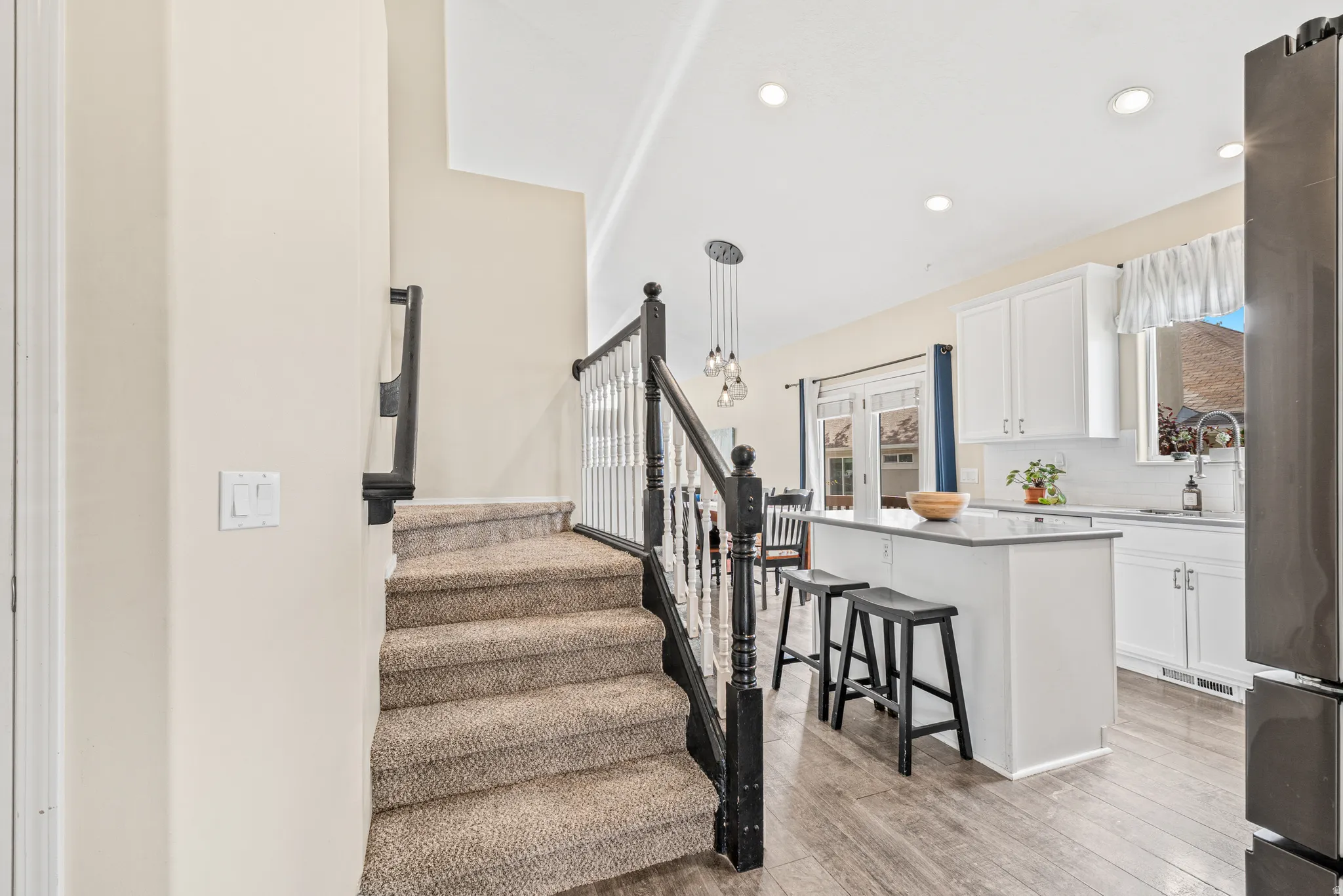 Carpeted staircase with dark wood newel posts and white spindles