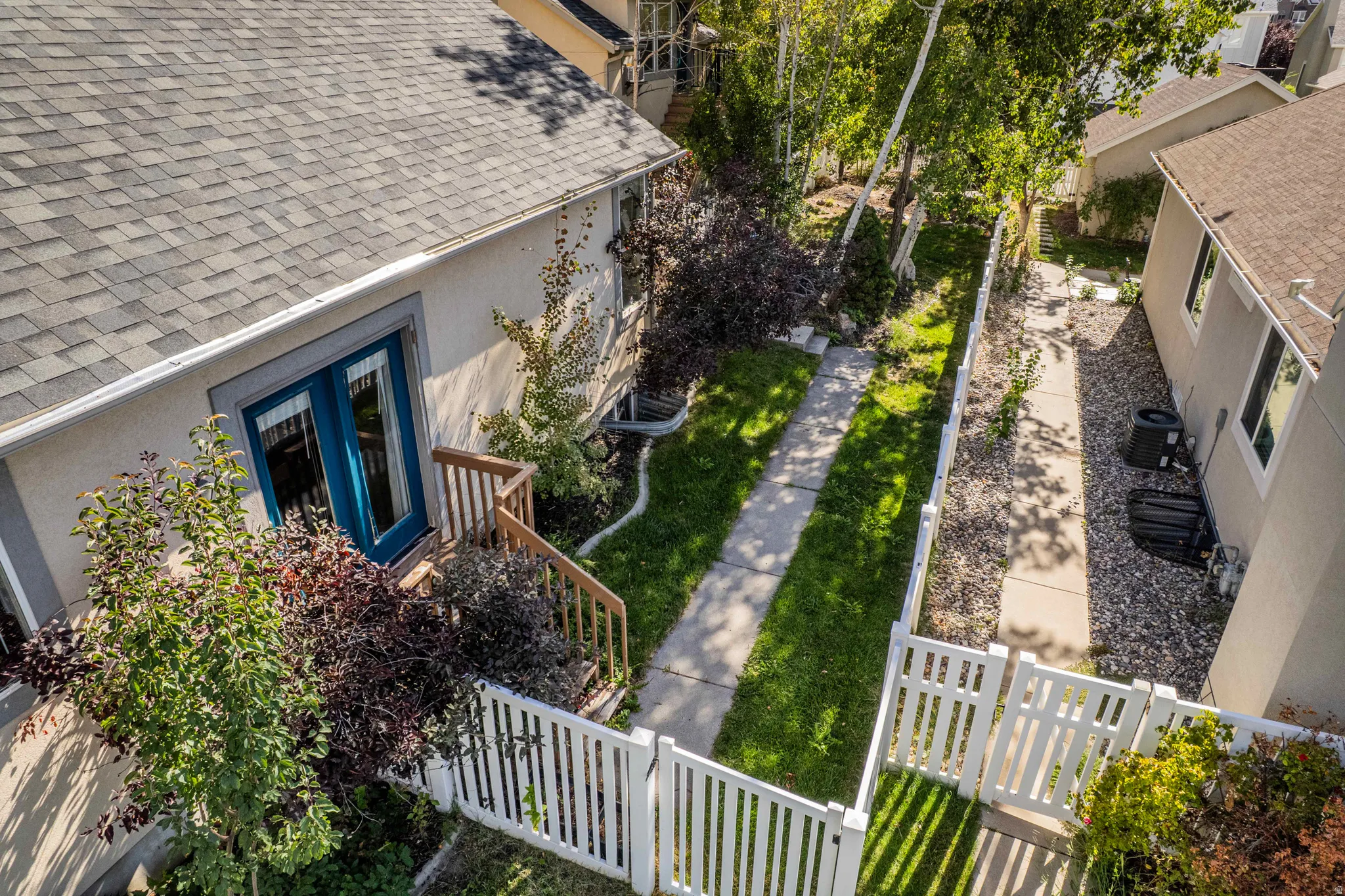 Exterior featuring a gabled roof, stucco siding, and a white picket fence