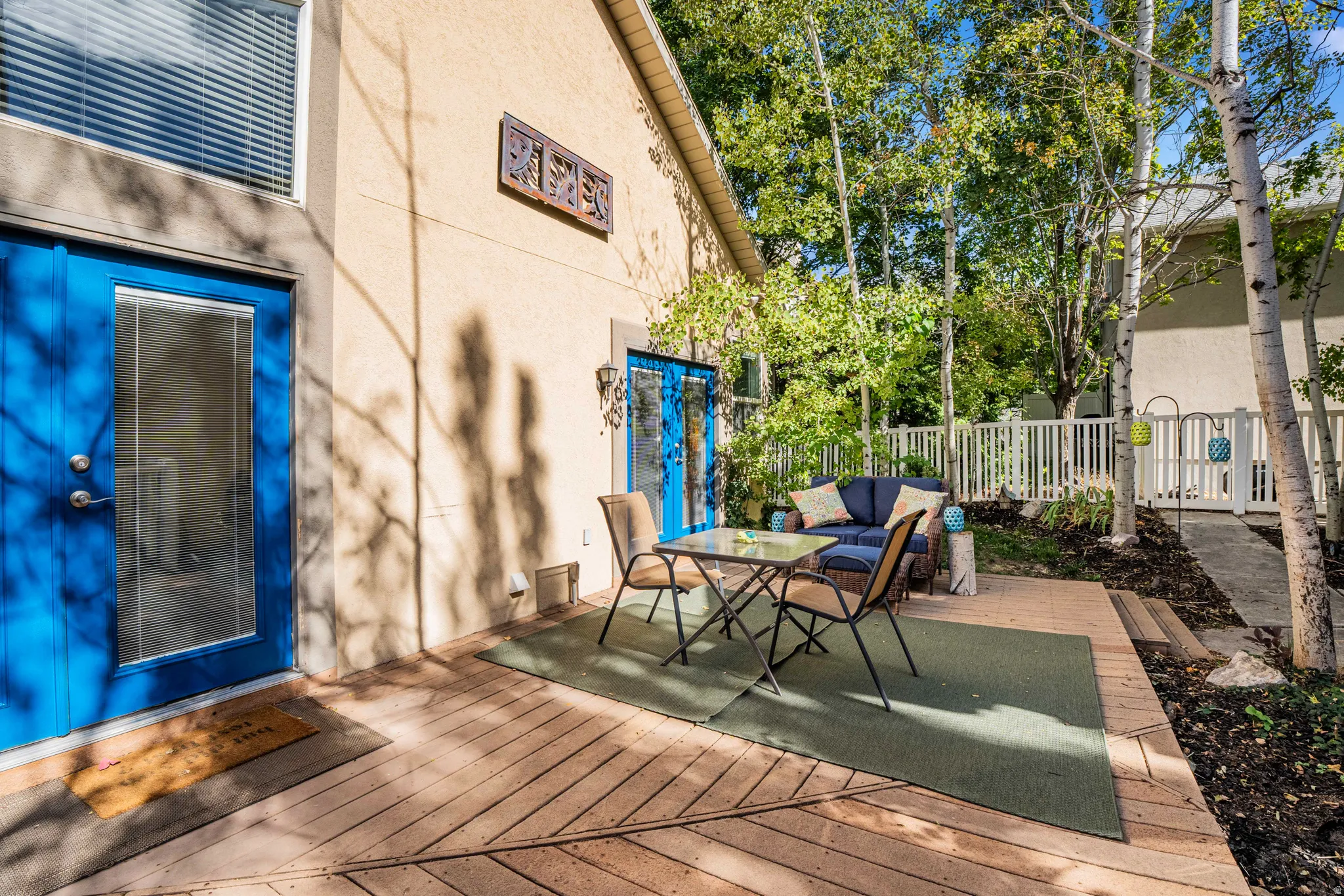 Expansive wooden deck with a patio area and mature trees