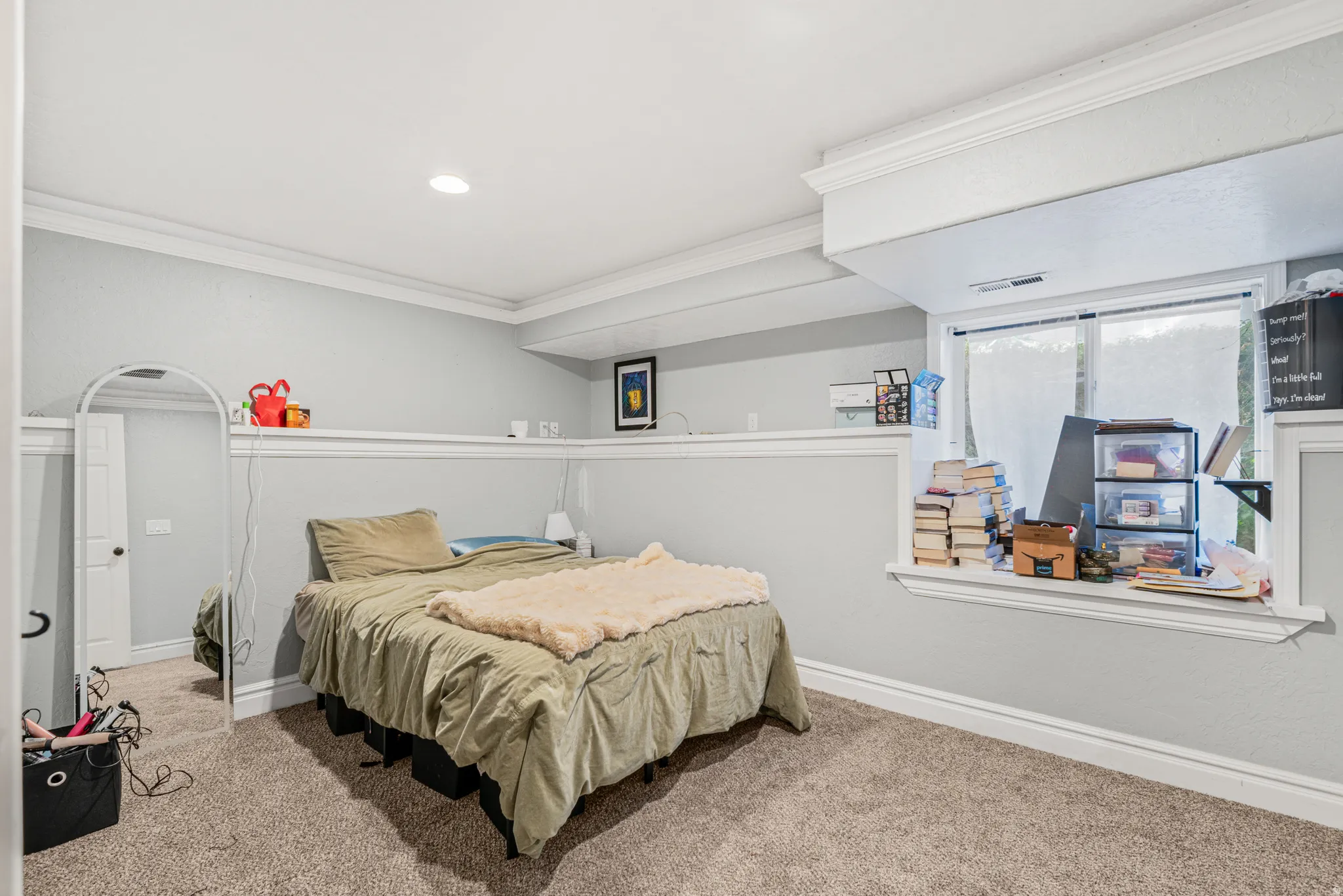 Carpeted flooring, recessed ceiling lighting, crown molding, chair rail molding, and a double-pane window