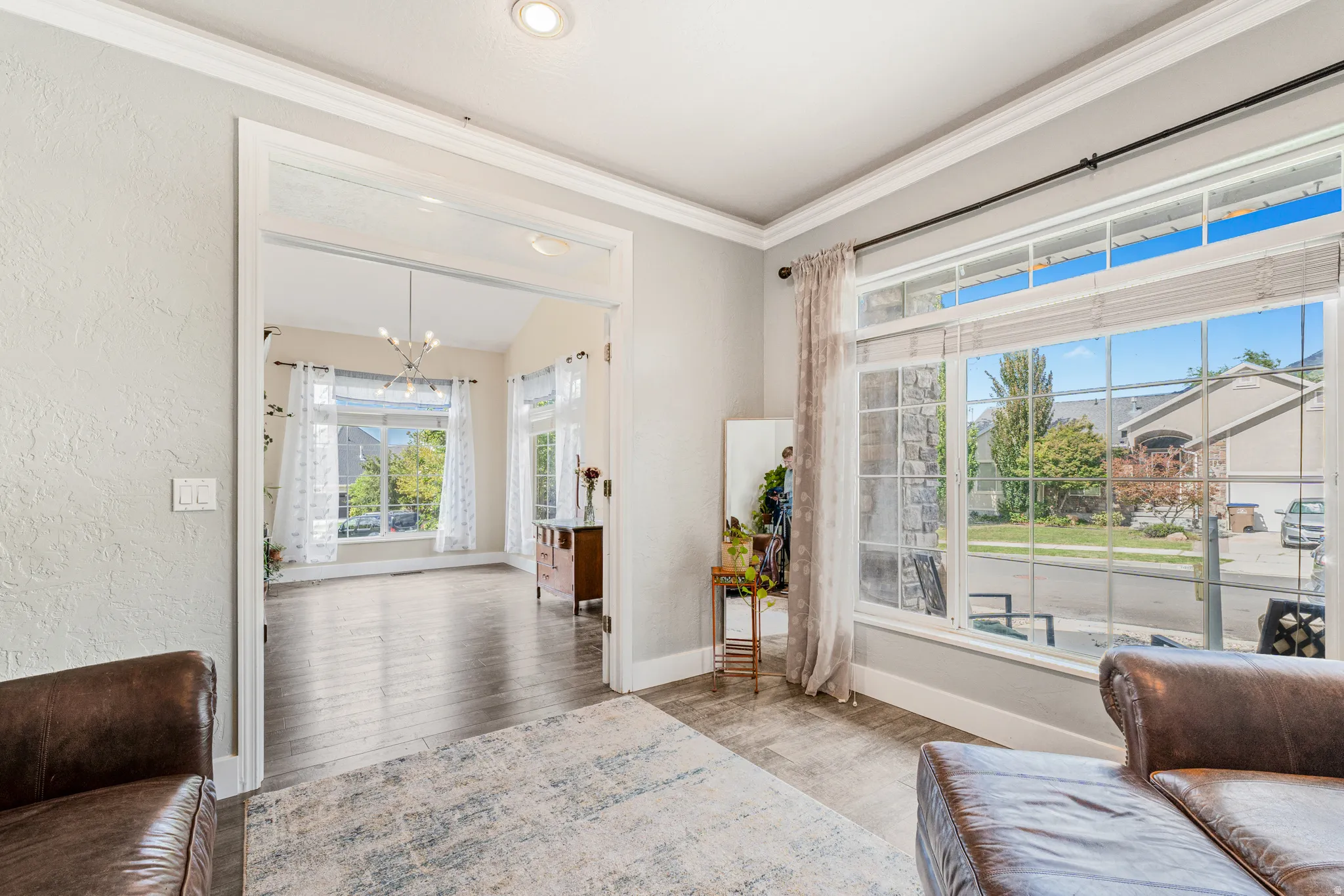 Wood-finish flooring throughout, recessed ceiling lighting, crown molding, and large multi-pane windows