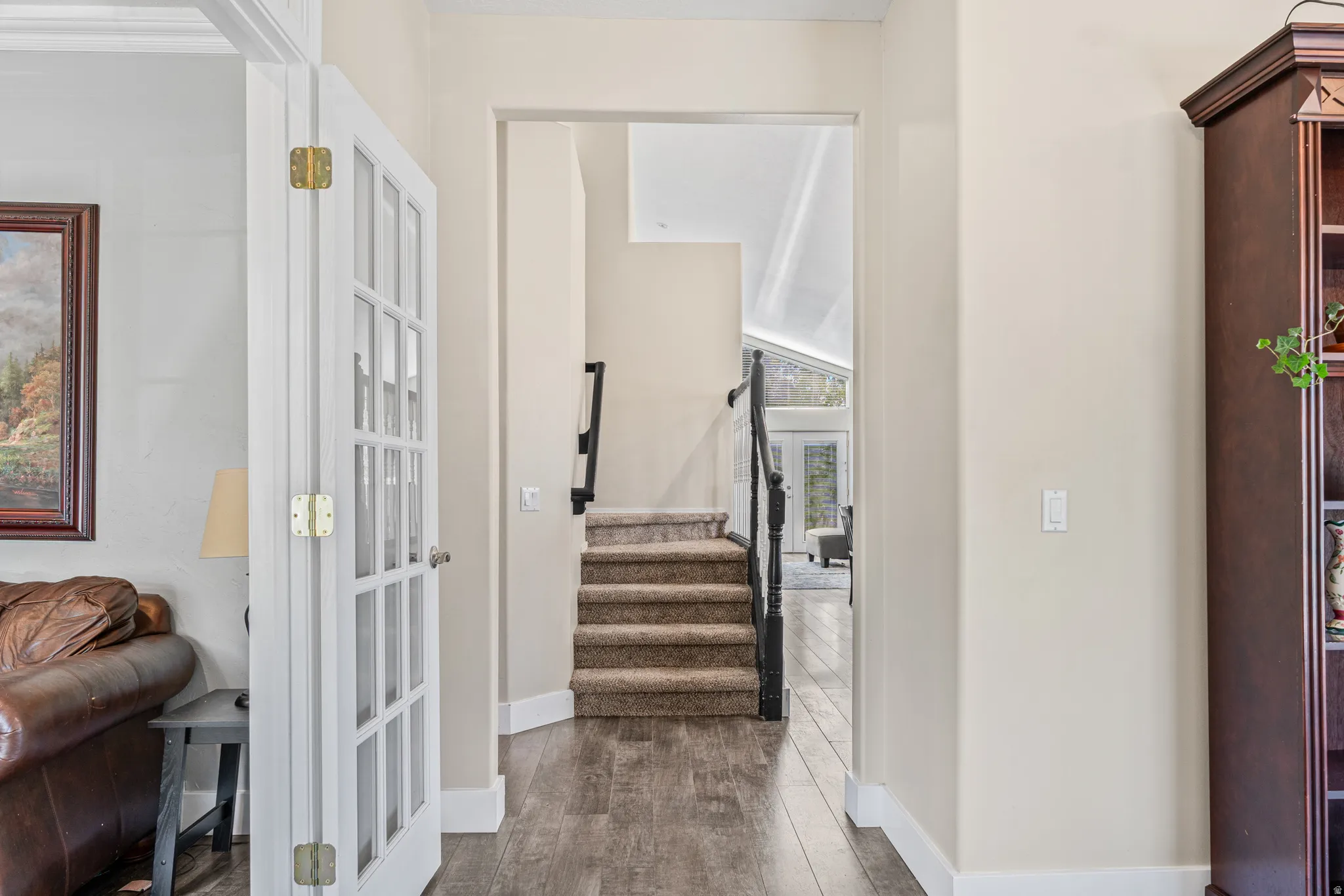 Wood-finish flooring, white trim, and a built-in wood-finish shelving unit