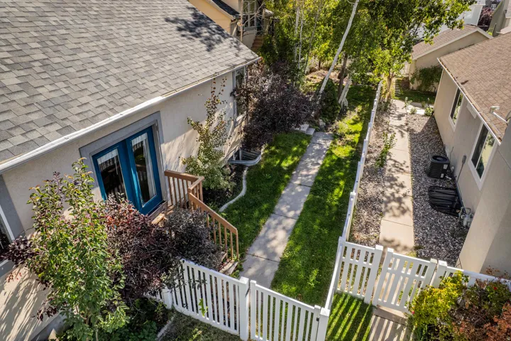 Exterior featuring a gabled roof, stucco siding, and a white picket fence
