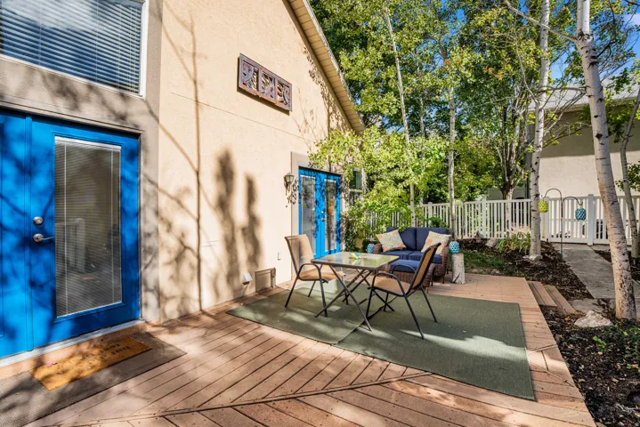 Expansive wooden deck with a patio area and mature trees
