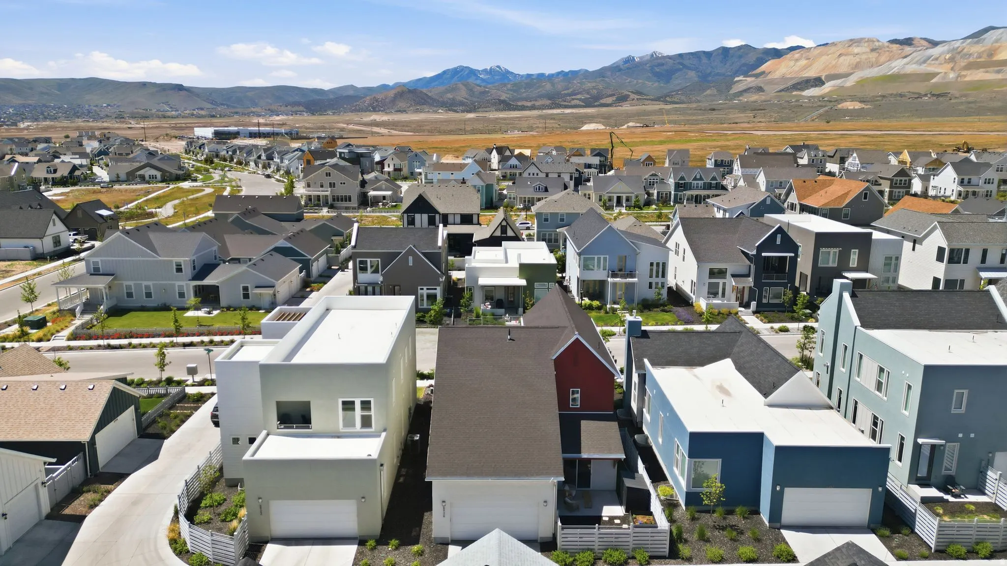 Residential community featuring a variety of architectural styles, paved streets, and landscaped common areas