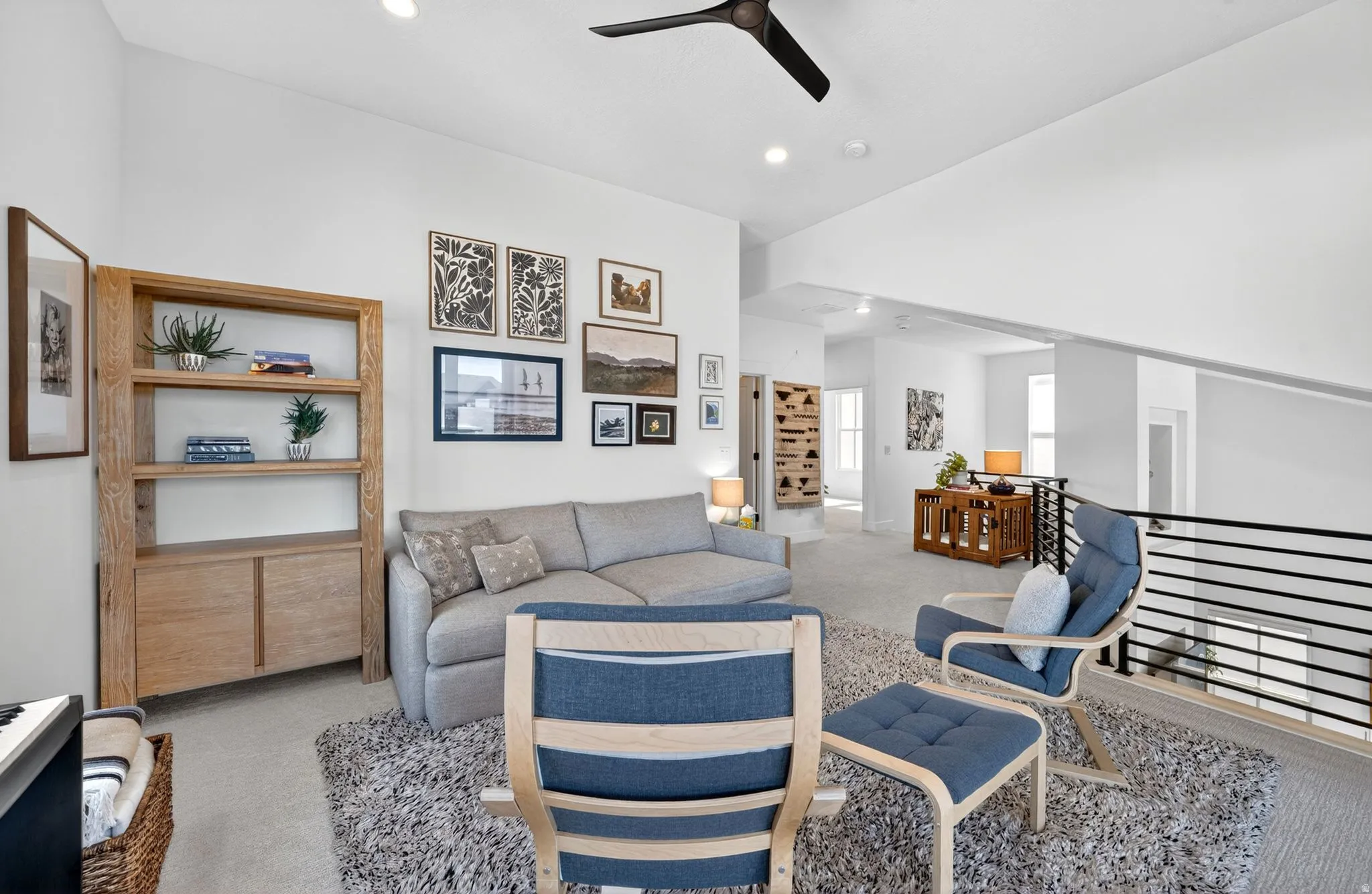 Open-concept loft space featuring a vaulted ceiling with a ceiling fan, recessed lighting, and light-toned carpeting