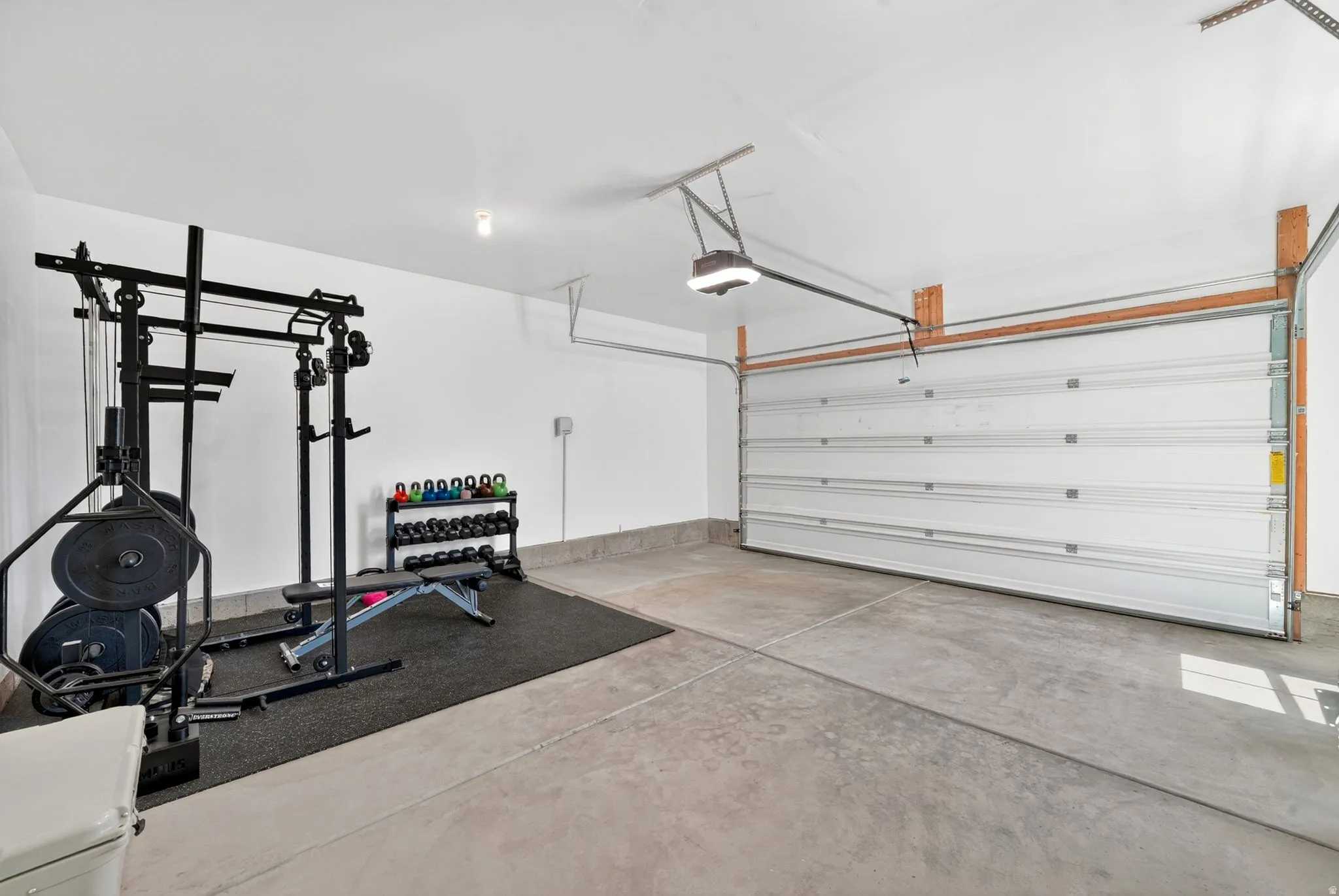 Spacious garage featuring a concrete floor, white painted walls, and an overhead garage door