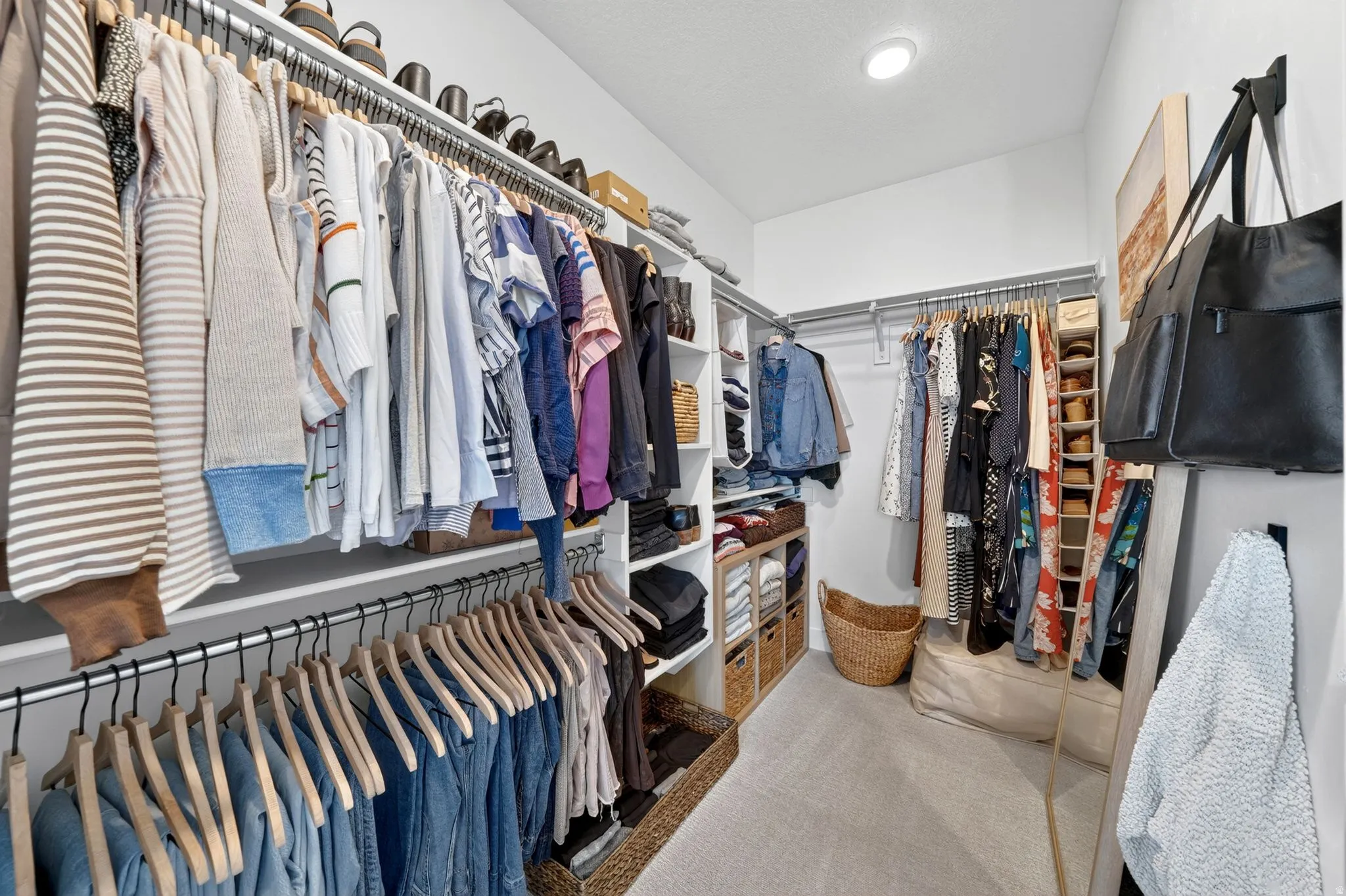 Walk-in closet featuring built-in shelving, multiple hanging rods, recessed ceiling lighting, and carpet flooring