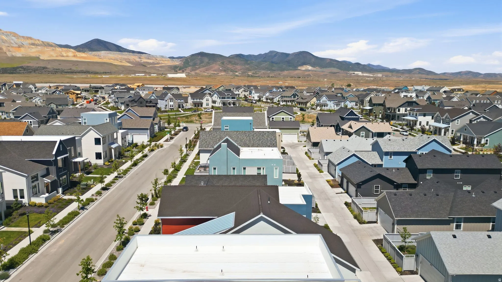 Expansive neighborhood featuring various architectural home styles, paved streets, sidewalks, and street trees