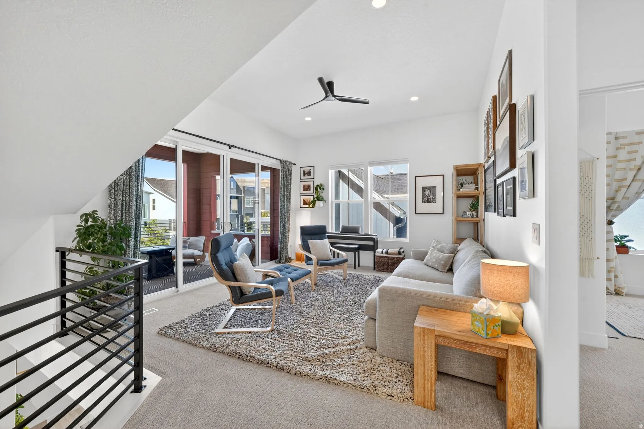 Upper-level living area with extensive natural light from multiple windows and sliding glass doors