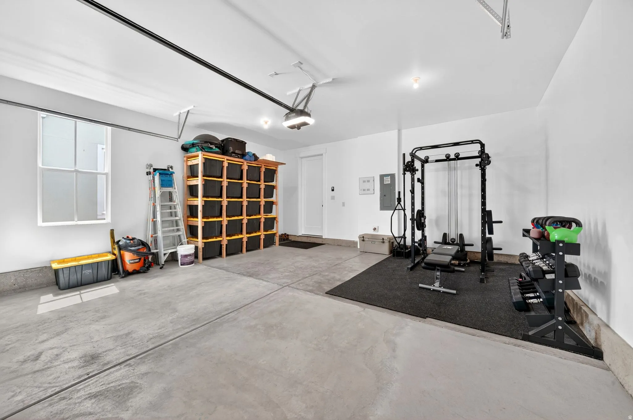 Spacious garage featuring concrete flooring, white walls, and a large window providing natural light
