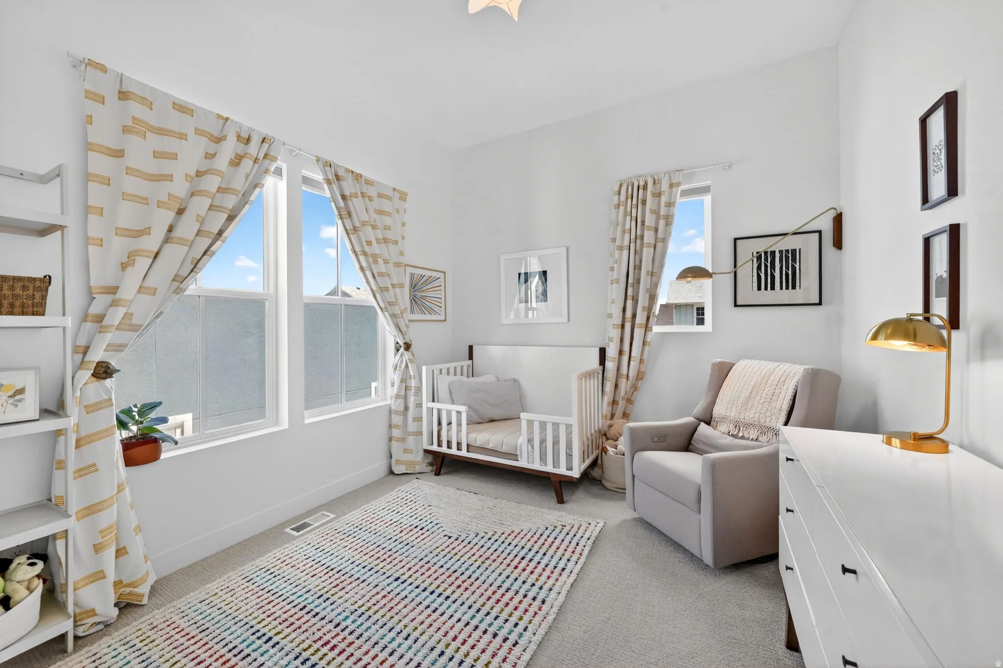 Bright interior room featuring a pair of large windows, light-toned carpeting, and white walls