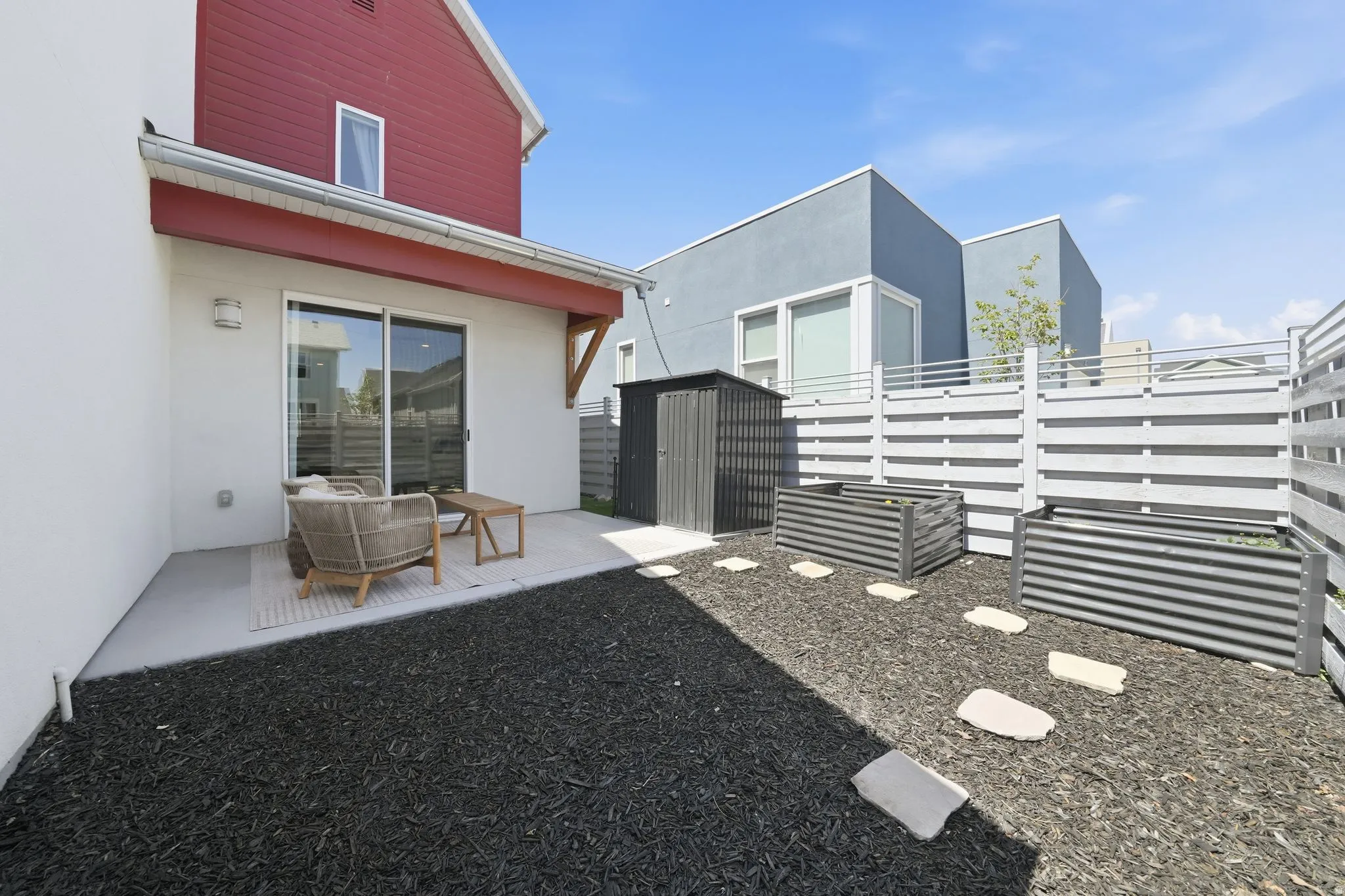 Private outdoor patio with a sliding glass door entry, overhead awning, and exterior lighting