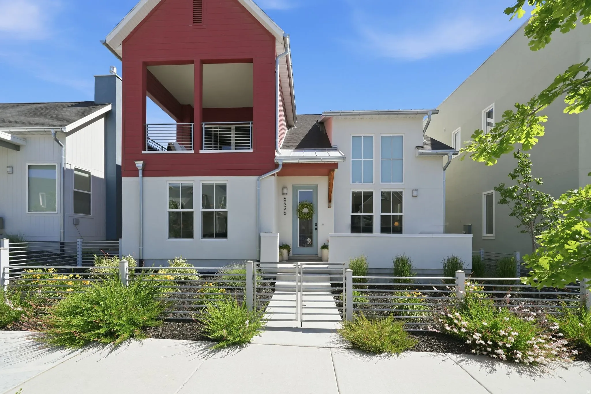 Contemporary facade featuring white stucco and red vertical siding