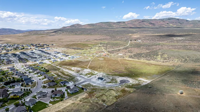 Expansive aerial view showcasing a developed residential community with established homes and new construction