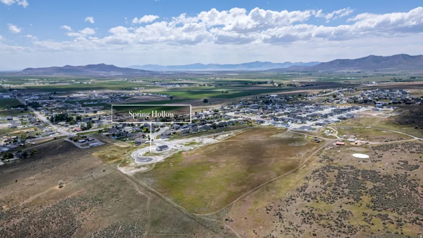 Aerial perspective showcasing the Spring Hollow community with visible residential structures and surrounding undeveloped land