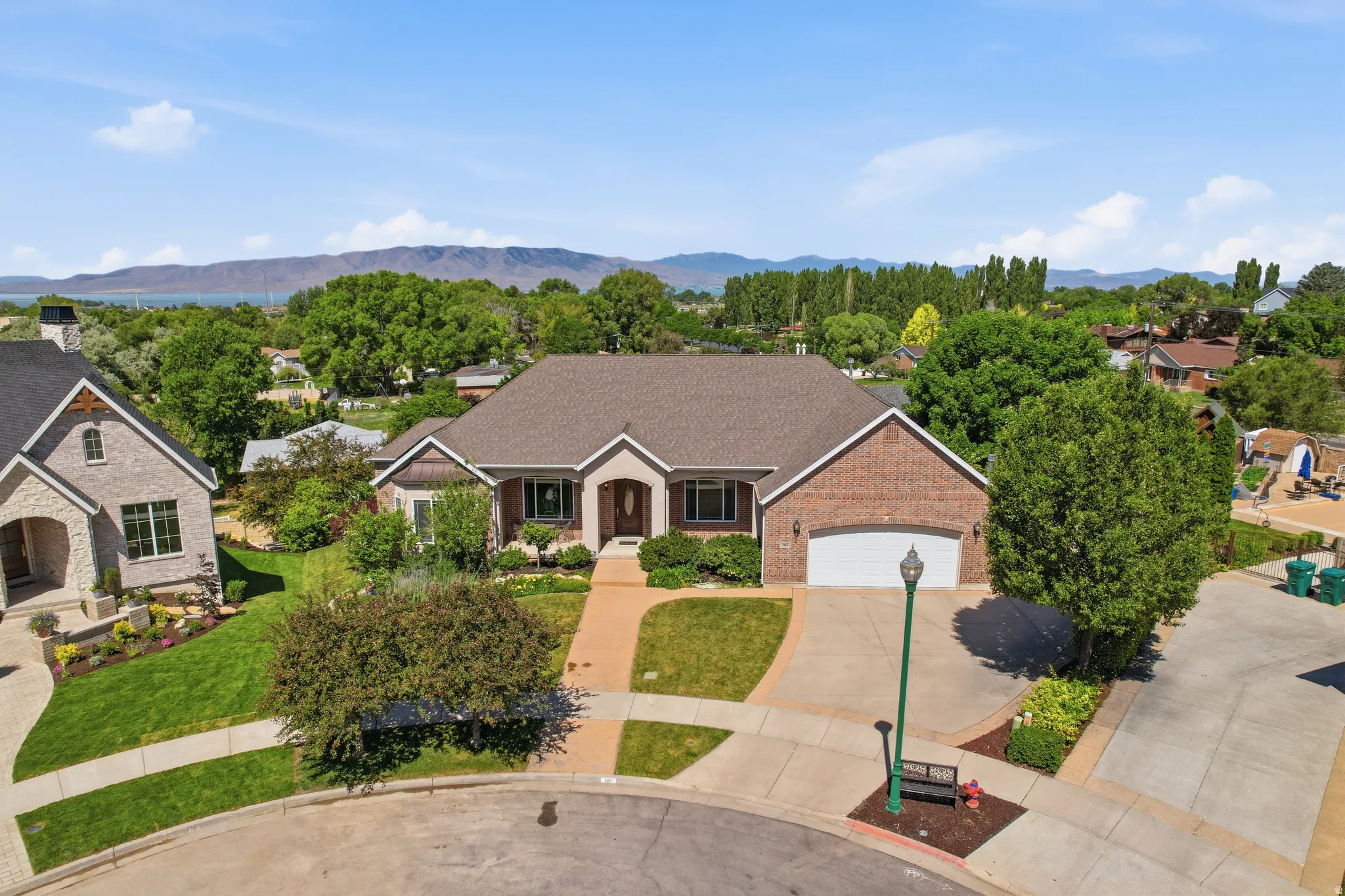 Brick-front exterior with a multi-gabled roofline, an attached garage, and a concrete driveway