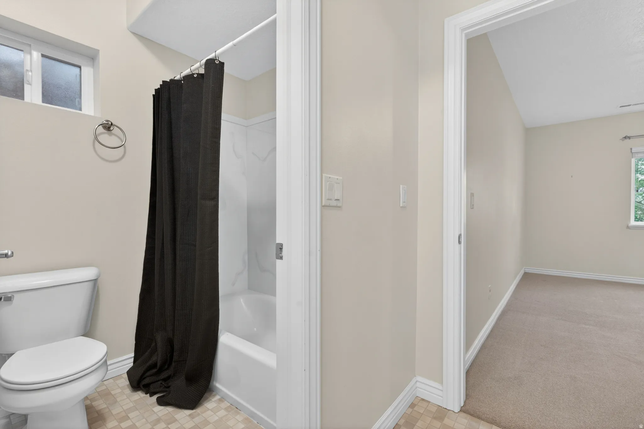 Bathroom featuring a white toilet, tiled flooring, and a shower/tub combination with a white surround