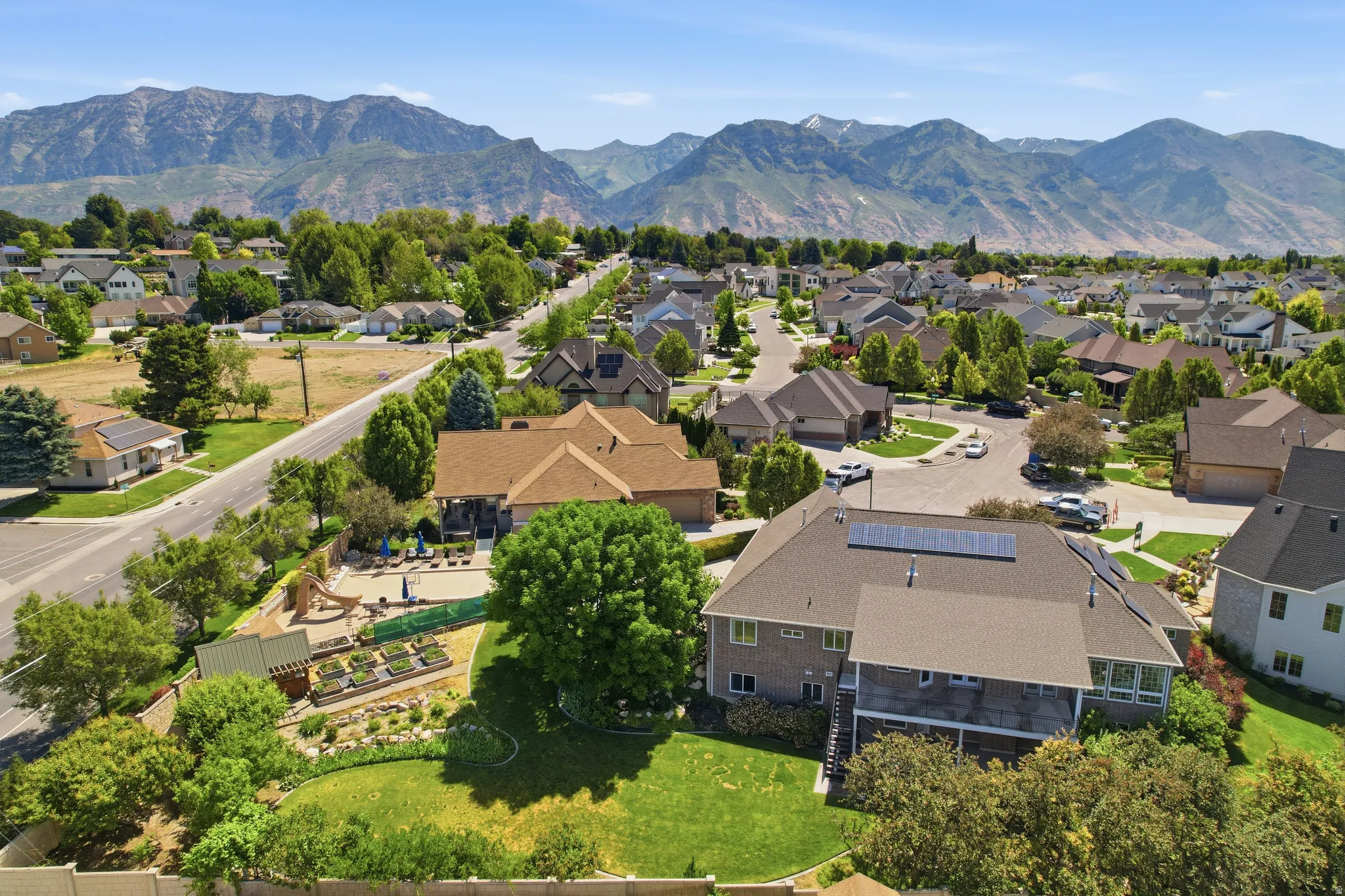 Expansive neighborhood setting featuring a mountainous backdrop, mature trees, and a variety of residential properties